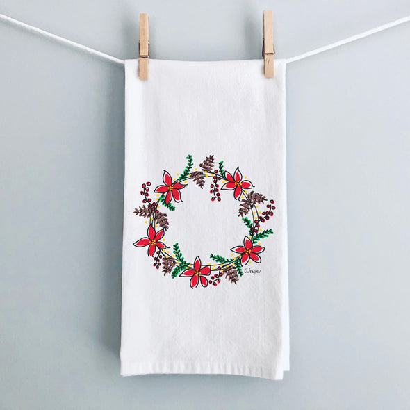 Poinsettias & Pinecones Christmas flour sack tea towel by Debbie Vinyard hanging for display, holiday kitchen décor gift.